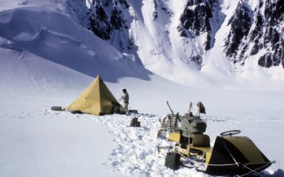 A man riding on top of a snow covered mountain.
