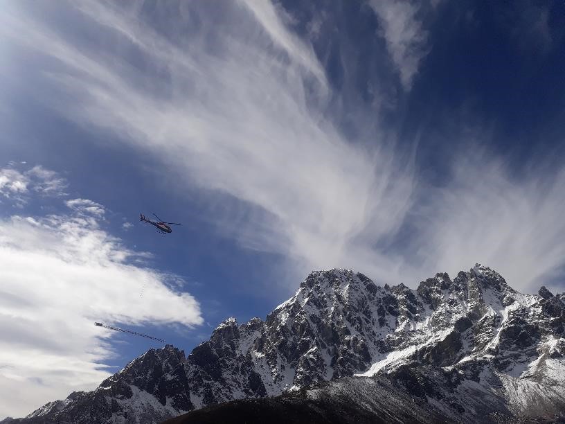 A person flying through the air on top of a mountain