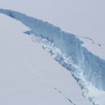 A person riding skis down a snow covered mountain.