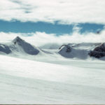A man riding skis down a snow covered mountain.