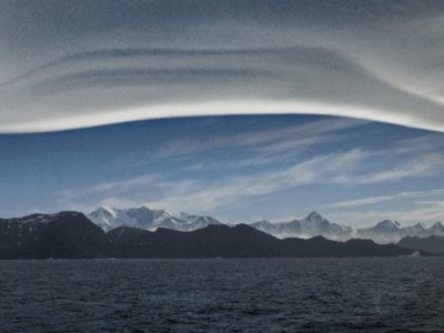 A large body of water with a mountain in the background.