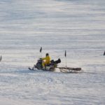 A group of people riding skis on top of a snow covered slope.