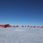 A group of people riding skis on top of a snow covered slope.