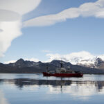 A large body of water with a mountain in the background