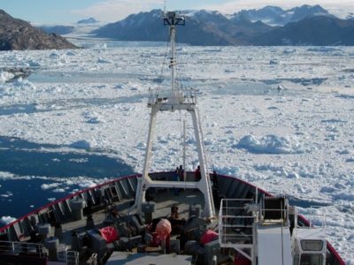 A boat floating on top of a snow covered mountain