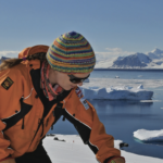 Cleaning the All-Sky Camera portal on top of the optical caboose at Rothera Research Station
