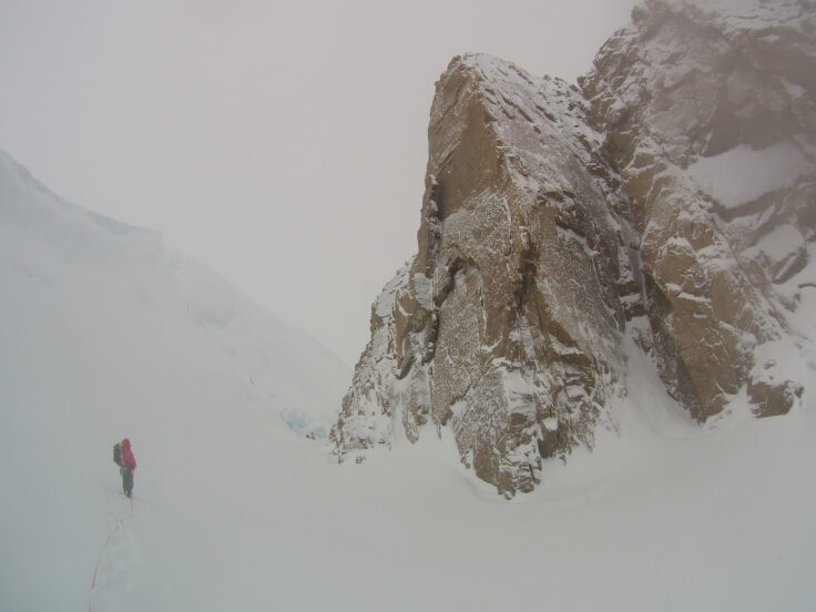 A group of people standing on top of a snow covered slope