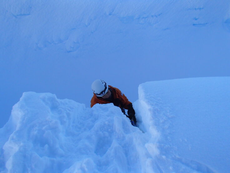 A person flying through the air on a snow covered mountain