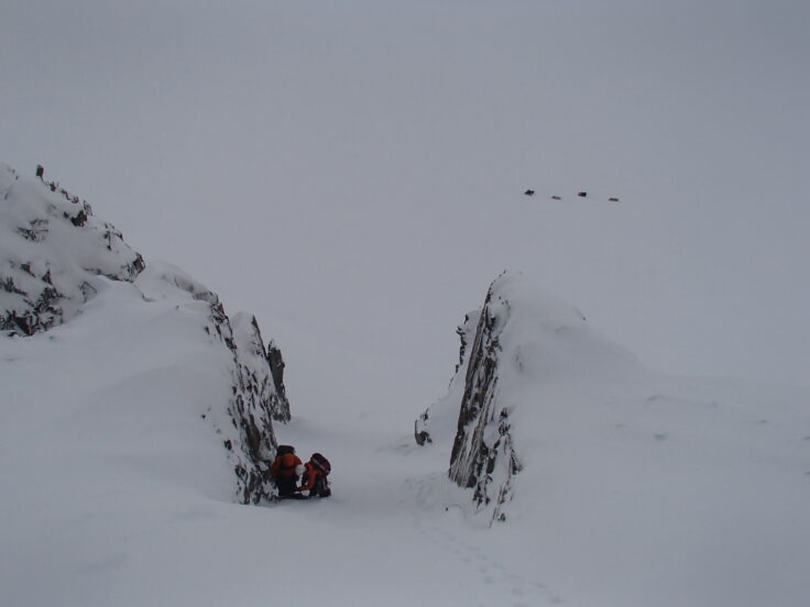 A person flying through the air on a snow covered slope