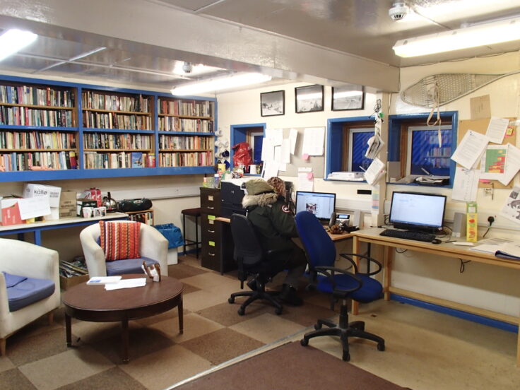 A living room filled with furniture and a table in a library