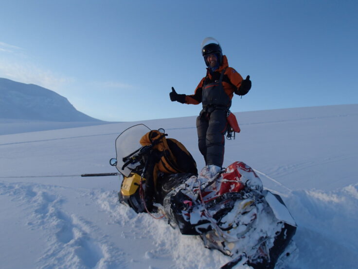 A man riding skis down a snow covered mountain