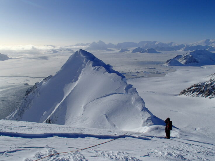 A man riding skis down a snow covered mountain