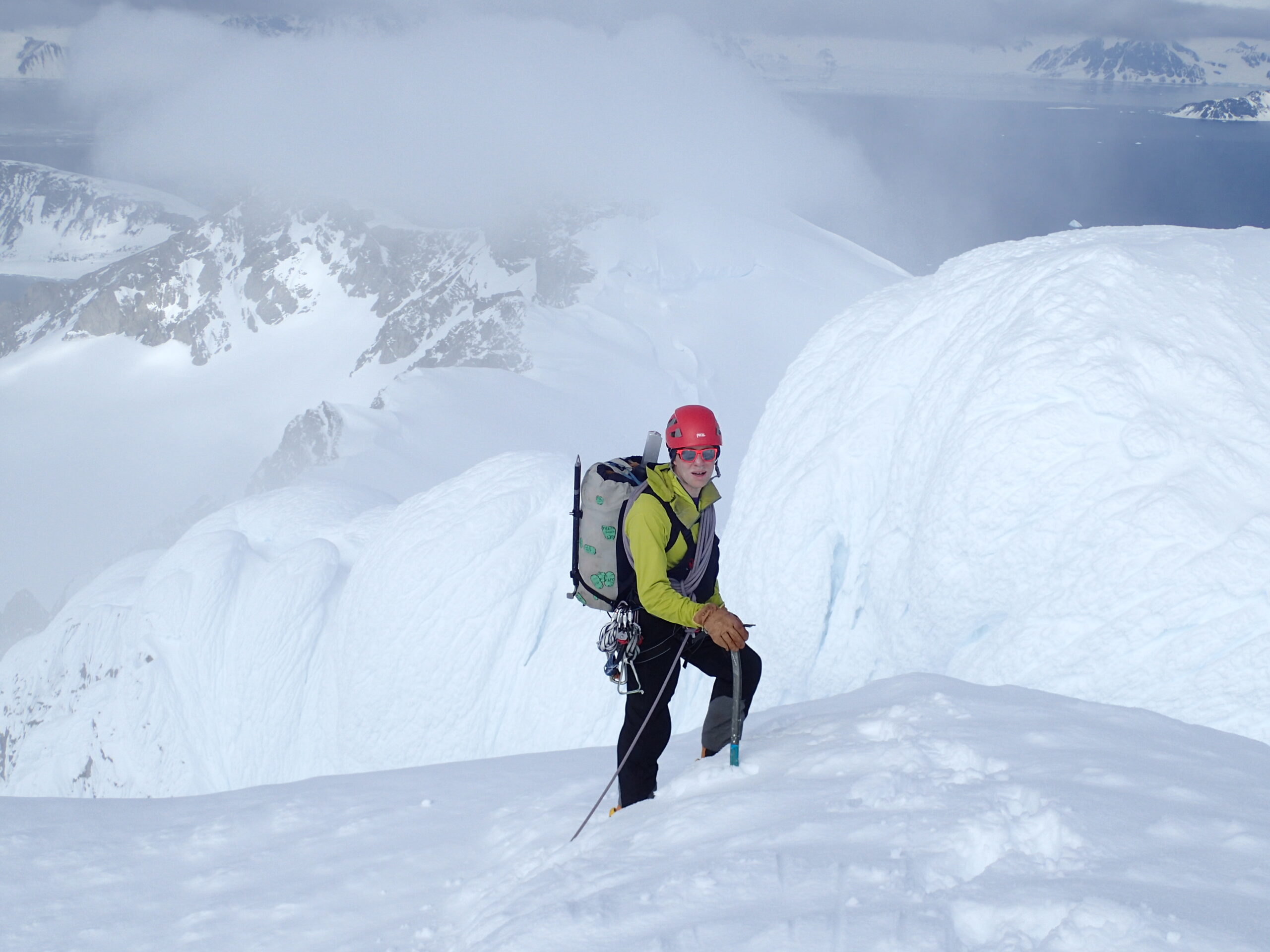 A man riding a snowboard down a snow covered slope