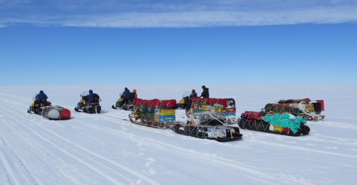 A group of people riding skis down a snow covered slope