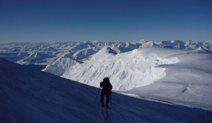 A man standing on top of a snow covered mountain