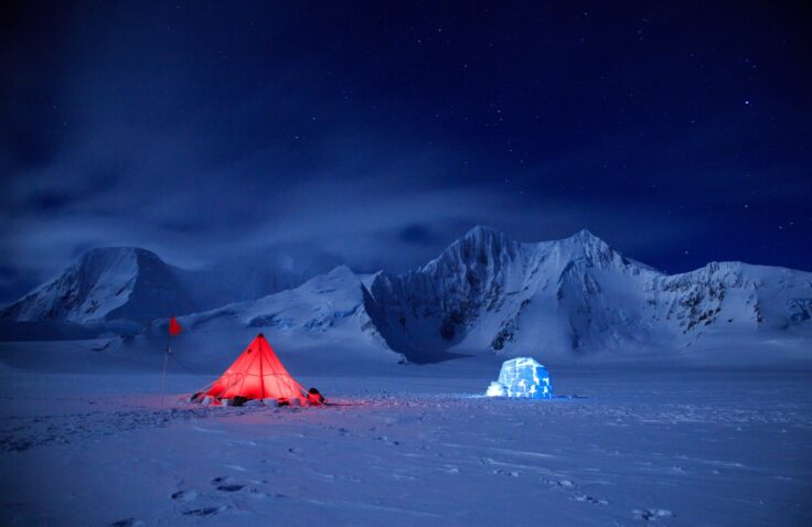 A fire hydrant on the side of a snow covered mountain