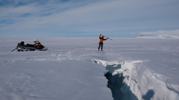A group of people riding skis down a snow covered slope