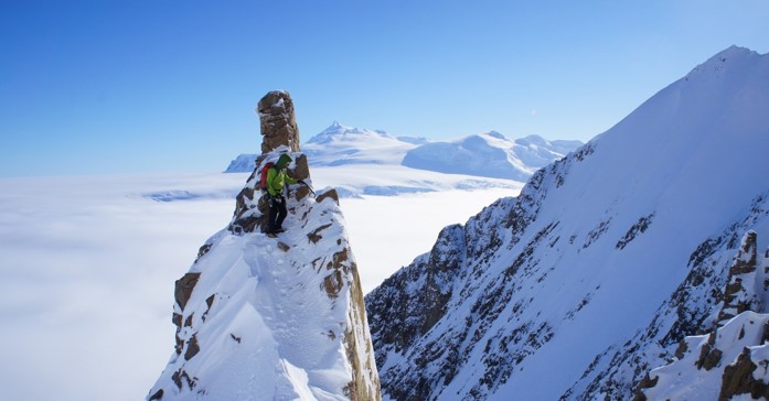 A man standing on top of a snow covered mountain
