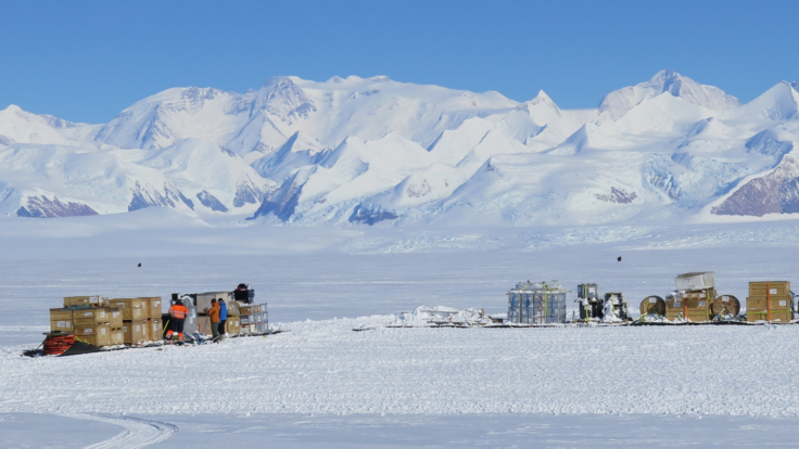 A group of people standing on top of a snow covered mountain