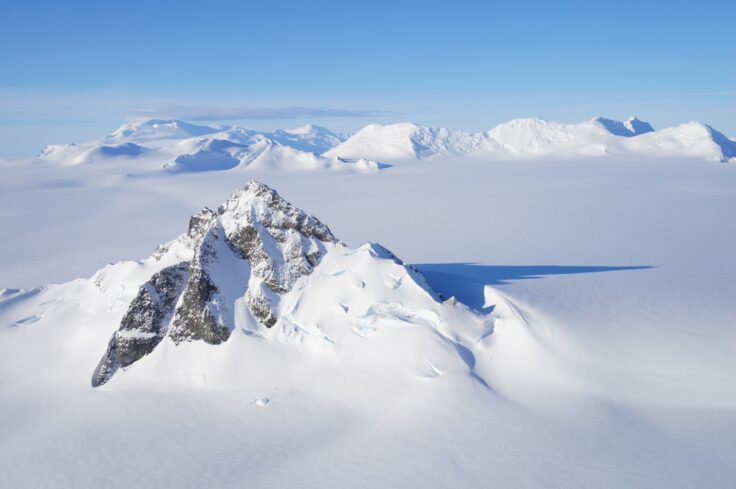 A man riding skis down a snow covered mountain