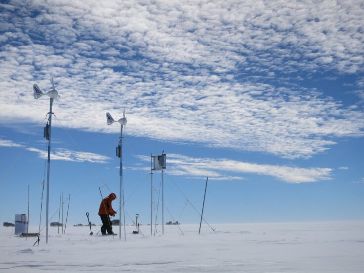 A group of people riding skis across snow covered ground