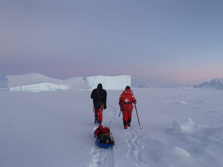A group of people standing on top of a snow covered slope