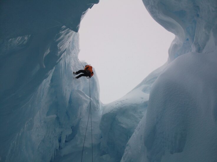 A person standing on top of a snow covered mountain
