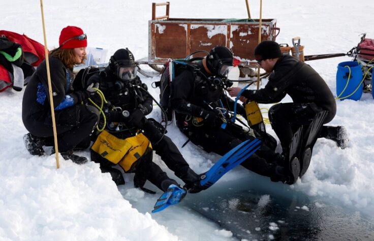 A group of people sitting in the snow
