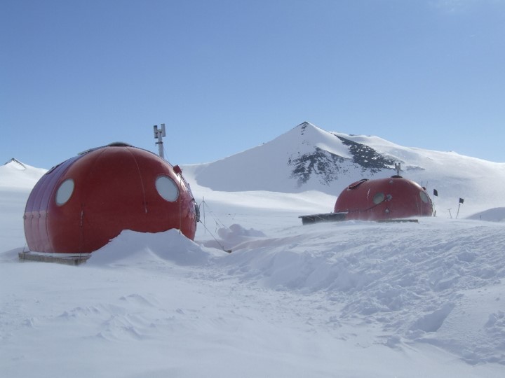 A man riding a snowboard down a snow covered mountain