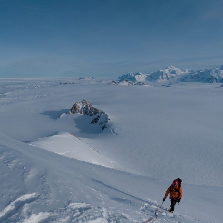 A man riding skis down a snow covered mountain