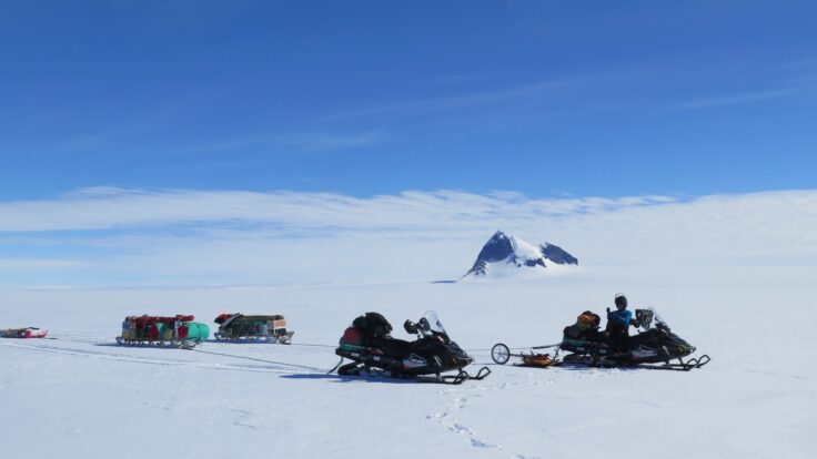A group of people sitting in the snow