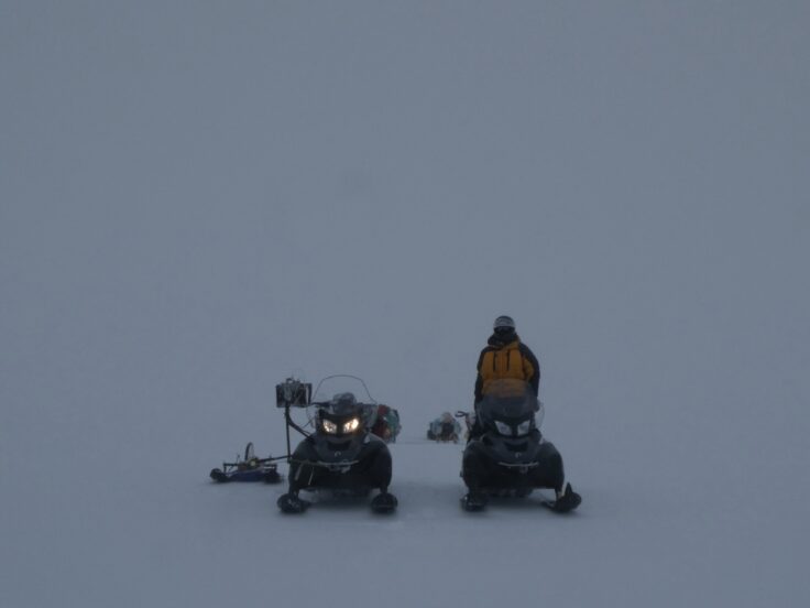 A couple of people that are sitting in the snow