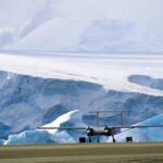 A plane sitting on top of a snow covered mountain