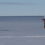 A man is cross country skiing in the water