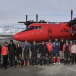 A group of people standing around a plane
