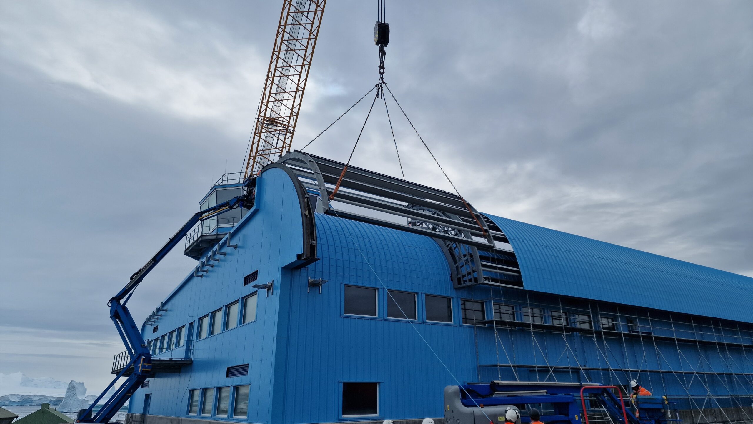 A large crane on top of a large blue building